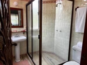 y baño con ducha y lavamanos. en Casa Bugambilia, Un Pequeño Hotel en Tepoztlán, en Tepoztlán