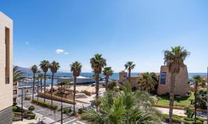 a view of a resort with palm trees and the ocean at Apartamento El Castillo in Roquetas de Mar