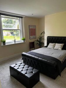 a bedroom with a large bed and a window at No.2 Beechcroft / Park-Side / Ping Pong & Garden in Liverpool