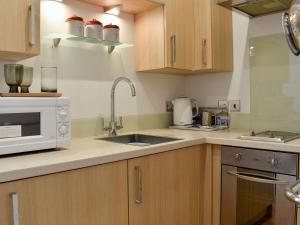 a kitchen with a sink and a microwave at Sandcastles in Swanage