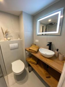 La salle de bains est pourvue d'un lavabo, de toilettes et d'un miroir. dans l'établissement Appartements neuf - Frontière de Monaco - clim - WIFI, à Cap d'Ail