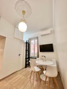 une salle à manger avec une table et des chaises blanches dans l'établissement Appartements neuf - Frontière de Monaco - clim - WIFI, à Cap d'Ail