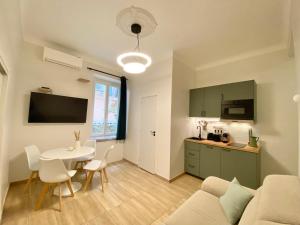 Appartements neuf - Frontière de Monaco - clim - WIFI في كاب دايل: غرفة معيشة مع أريكة وطاولة ومطبخ