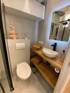 La salle de bains est pourvue de toilettes blanches et d'un lavabo. dans l'établissement Appartements neuf - Frontière de Monaco - clim - WIFI, à Cap d'Ail