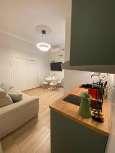 Appartements neuf - Frontière de Monaco - clim - WIFI في كاب دايل: مطبخ وغرفة معيشة مع أريكة وطاولة