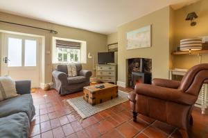 a living room with two couches and a fireplace at Pear Tree Cottage 2 in Holme next the Sea