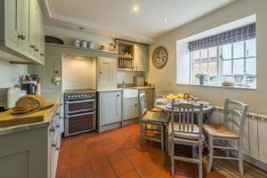 a kitchen with a table and a table and chairs at Pear Tree Cottage 2 in Holme next the Sea