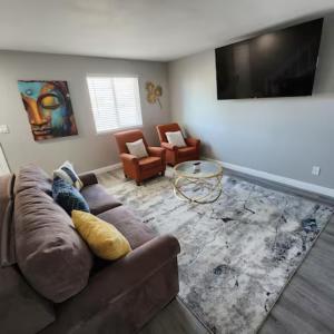 uma sala de estar com um sofá e uma televisão de ecrã plano em All New! Convenient Location! Sleeps 8 em Denver