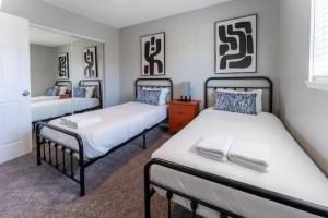 1 dormitorio con 2 camas y espejo en All New! Convenient Location! Sleeps 8 en Denver