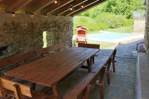 una mesa de madera en un patio con una pared de piedra en Casa Cocola, en Cerovlje