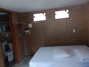 - une chambre avec un lit et un mur en briques dans l'établissement Casa em Duas Barras a 45 minutos de Nova Friburgo, à Duas Barras