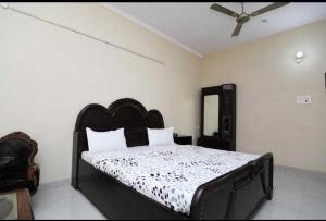 a bedroom with a bed and a ceiling fan at POP Hotel Amrit Castle 2 in Morādābād