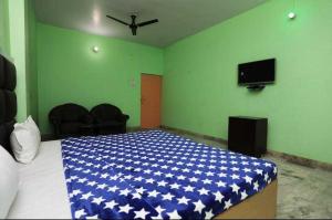 a bedroom with a bed with a blue cover on it at POP Hotel Amrit Castle 2 in Morādābād