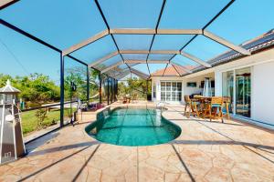 een zwembad met een pergola op een patio bij Blazing Sunshine in Bonita Springs