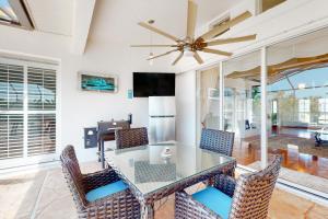 een eetkamer met een tafel en stoelen en een plafondventilator bij Blazing Sunshine in Bonita Springs