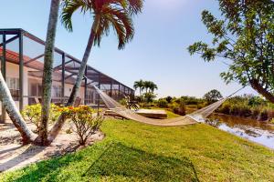 een hangmat tussen twee palmbomen voor een gebouw bij Blazing Sunshine in Bonita Springs