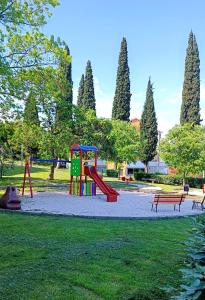 a playground with a slide in a park at Apartman Leona in Lovran