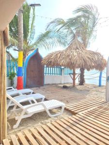 twee ligstoelen en een hut op het strand bij habitación frente al mar 102 in San Silvestre