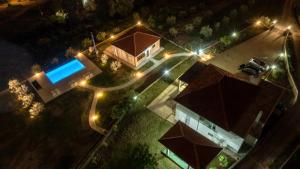 einen Ausblick über ein Haus mit Pool in der Nacht in der Unterkunft Uphill Glavanovic Villas in Bar