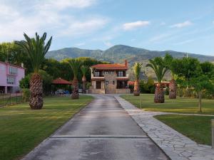 una entrada que conduce a una casa con palmeras en Villa Kallimanis, en Platanidia