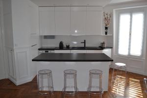 a kitchen with a counter and three bar stools at Appartement moulin rouge II in Paris