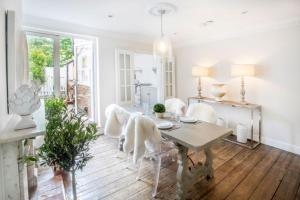 a dining room with a table and white chairs at Tide Cottage O in Overstrand