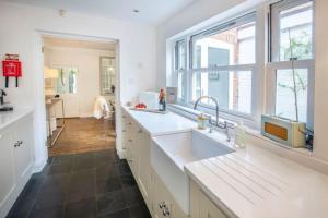 a kitchen with a sink and a large window at Tide Cottage O in Overstrand