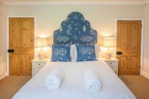 a bedroom with a large white bed with blue pillows at Tide Cottage O in Overstrand