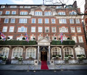 un gran edificio de ladrillo rojo con banderas delante en The Goring, en Londres