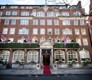a large red brick building with flags in front of it at The Goring in London