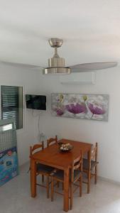 a dining room with a wooden table and chairs at Apartamento con piscina, Cala en Blanes Ciutadella in Cala en Blanes