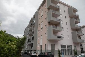 a tall building with cars parked in front of it at APARTMAN SONJA in Trebinje
