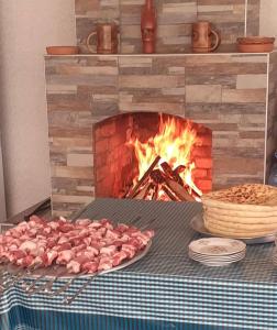 um monte de carne numa grelha ao lado de uma lareira em Guesthouse Vashlovani em Lagodekhi