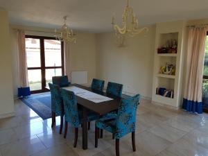 a dining room with a table and blue chairs at VILLA POMERANIA in Rowy