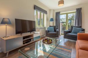 a living room with a large flat screen tv at Samphire House in Bodham