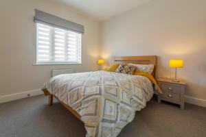 a bedroom with a bed and a window at Samphire House in Bodham