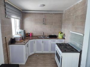 a kitchen with white cabinets and a stove top oven at Chalets in the middle of Ajloun forests شاليه و مزرعة في وسط غابات عجلون in Ajloun