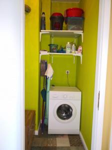 a laundry room with a washing machine in a green wall at Anna in Anklam