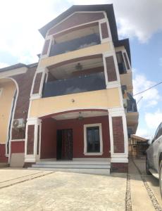 a red and white house with a car parked in front at Montrose Gardens in Lagos
