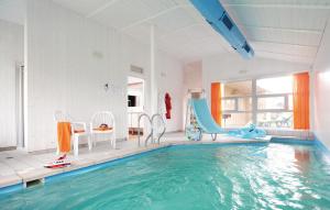 a indoor swimming pool with a slide and a swimming pool at Strandblick 36 in Schönhagen