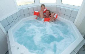 a man and two children sitting in a bath tub at Strandblick 36 in Schönhagen