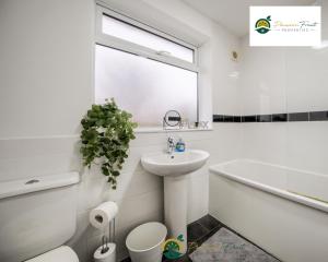 a white bathroom with a sink and a toilet and a tub at Low Rate 3 Bedroom House Very Close To Coventry Building Society Arena aka Ricoh Arena, Sleeps 8, Free Driveway Parking and Free Wi-Fi, with Garden - RRN in Exhall +28 photos