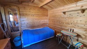 a room with a blue bed in a wooden cabin at Ostseebad-Zinnowitz-Knuffeliges-Ferienzimmer-im-Holzhaus in Zinnowitz