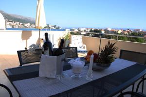 una mesa con botellas de vino y una bebida en el balcón en Apartment One Vision en Split