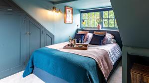 ein blaues Schlafzimmer mit einem Bett und einem Tablett darauf in der Unterkunft Cedar Cottage in Chipping Norton
