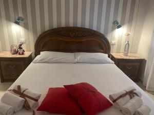 una camera da letto con un grande letto con asciugamani rossi e bianchi di Casa Vacanze “Il Sogno” a Bagnoregio