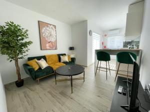 a living room with a green couch and a table at Our Charming House in Portimão