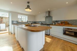 a large kitchen with a wooden counter top in a kitchen at Barn Cottage 6 in Salthouse