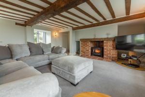 a living room with a couch and a fireplace at Barn Cottage 6 in Salthouse