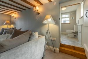a living room with a bed and a lamp and a toilet at Barn Cottage 6 in Salthouse +41 photos